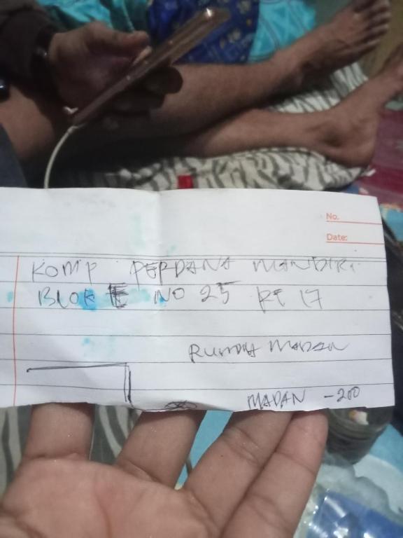 een persoon met een stuk papier met een handschrift erop bij HOTEL MELAYu in Banua Anyar