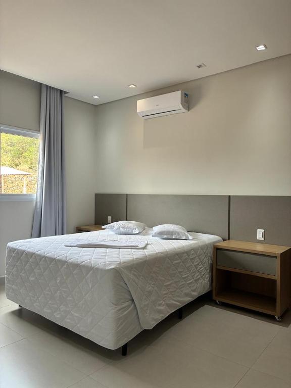 a bedroom with a large bed with a white comforter at Hotel São Francisco in Itaí