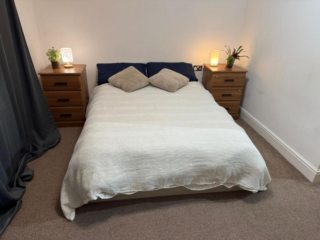 Un dormitorio con una cama grande con dos mesitas de noche. en Beautiful room- private bathroom, en Harrow