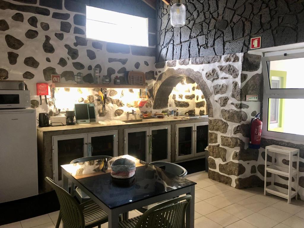 eine Küche mit einem Tisch und einer Steinmauer in der Unterkunft Xaminé in Água Retorta