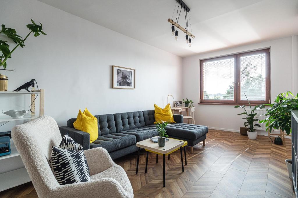a living room with a blue couch and yellow pillows at The Nest - Komárno in Komárno