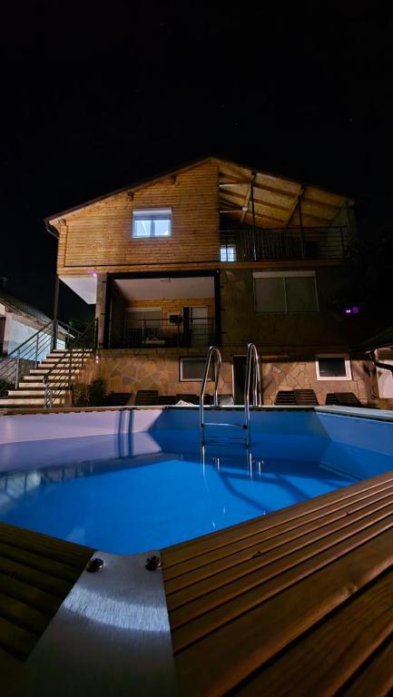 a swimming pool in front of a house at night at Vila Nemir Zavojsko jezero in Pirot