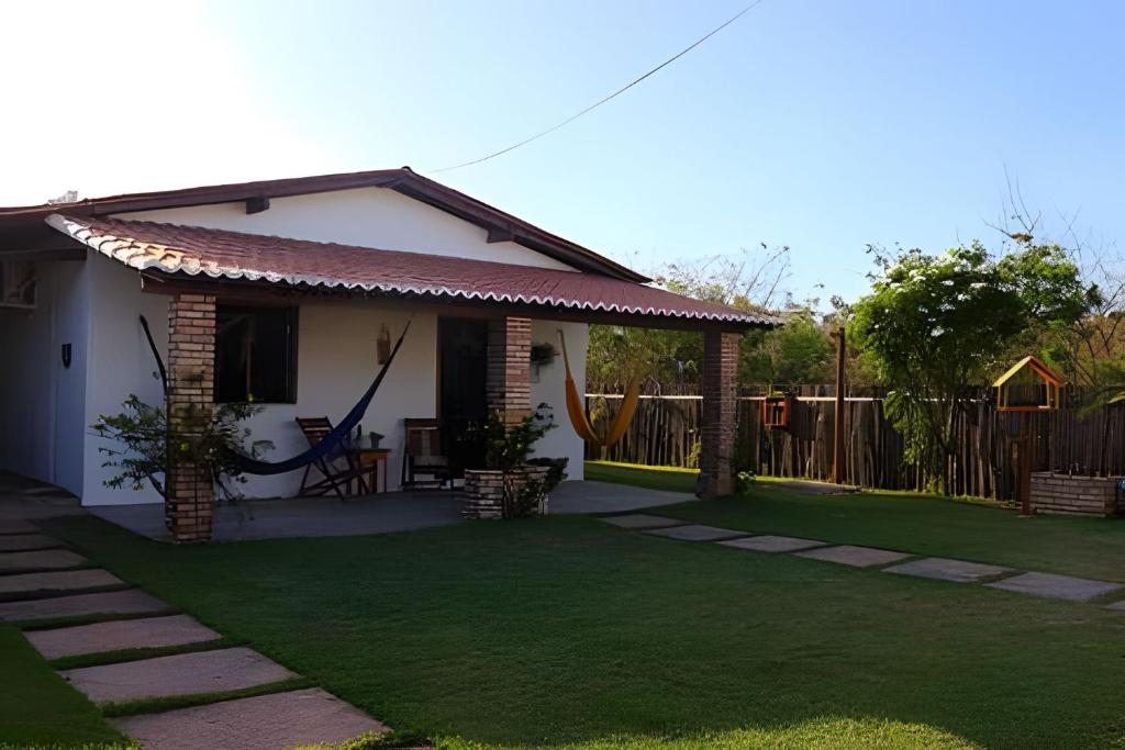 ein kleines Haus mit einem grünen Hof in der Unterkunft Casa charmosa em BG - Casa Trevo in Barra Grande
