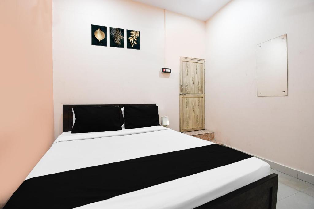 a white bedroom with a black and white bed at Super Hotel O Sofitel Hotel in Dhanbād