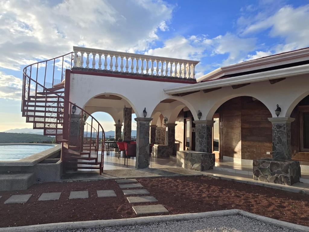 a building with a spiral staircase on top of it at Casona Cocobolo el mejor lugar de Costa Rica in Guanacaste