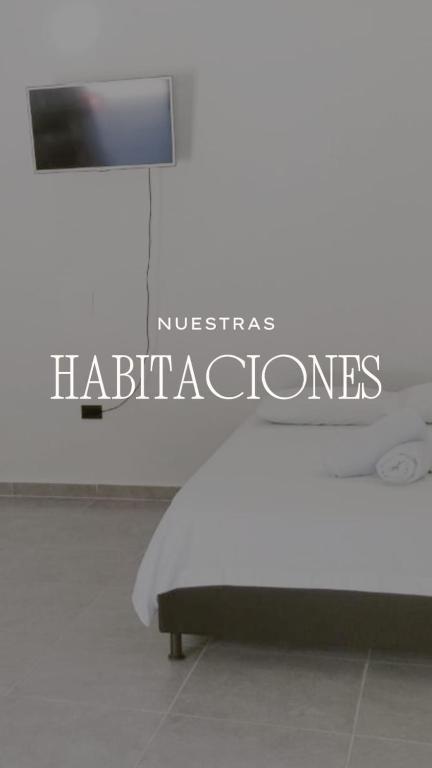 a bed in a room with a sign that reads nicabase habitats at JyM apartaestudios in Doradal
