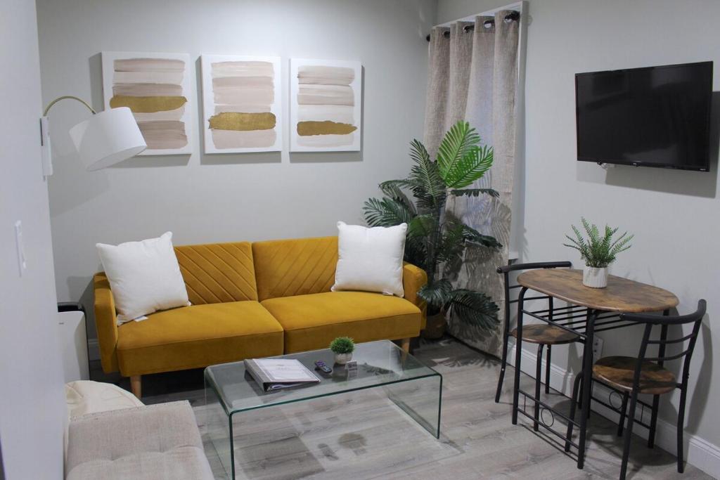 2 BEDROOM 1 BATH TRENDY Apt Downtown Albany في ألباني: غرفة معيشة مع أريكة صفراء وطاولة