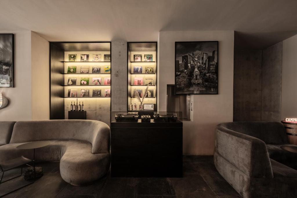 een woonkamer met 2 stoelen en een bank bij Hotel Casa Izel Roma Norte in Mexico-Stad