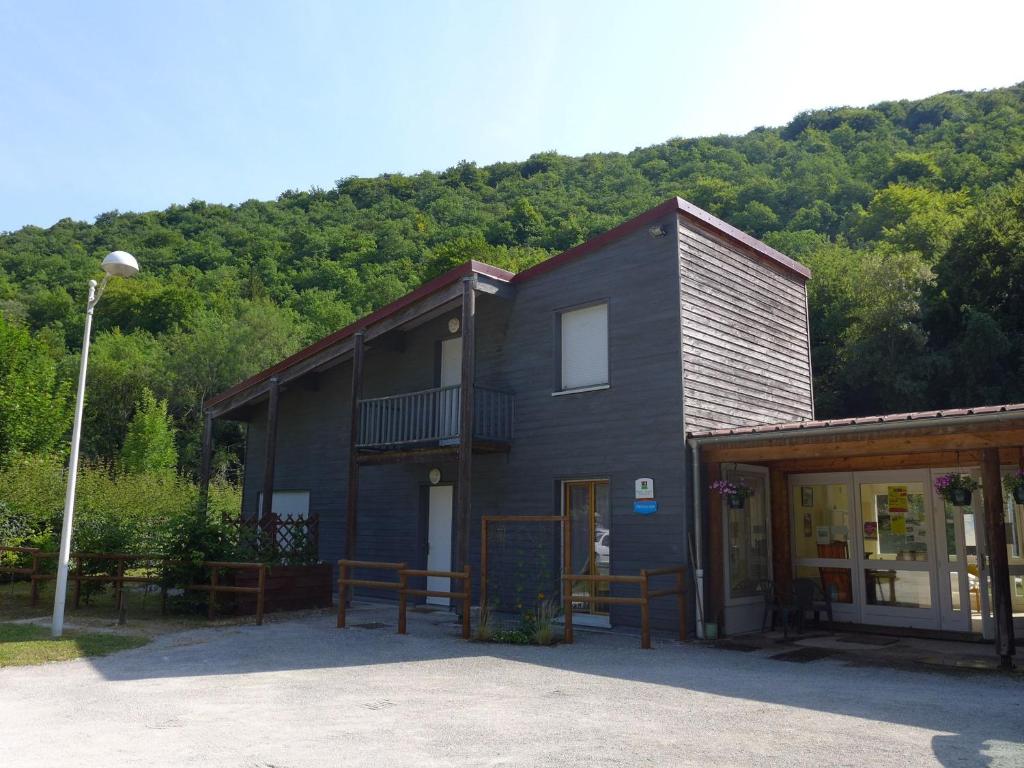 ein schwarzes Gebäude mit einem Balkon an der Seite in der Unterkunft Maison en bois au bord du canal avec terrasse et jeux - FR-1-611A-3 in Froncles