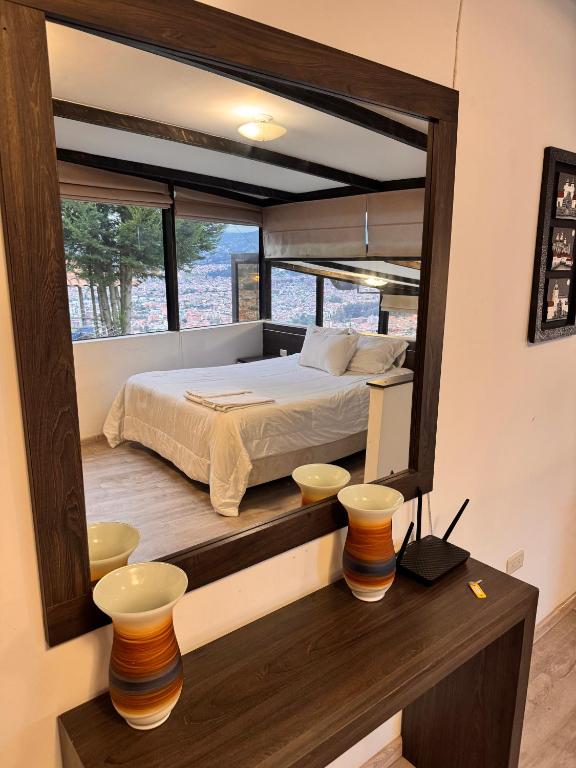 a bedroom with a bed and a large mirror at Azotea Suites & Apartments in Cuenca