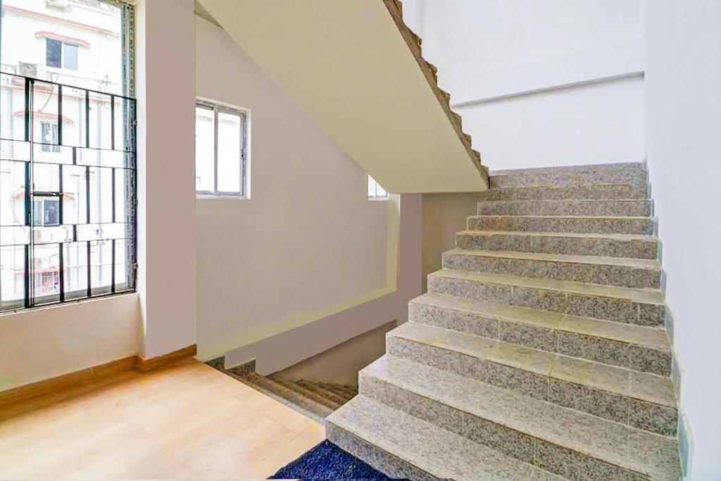 a staircase in an empty room with a window at Hotel O Assam Inn Grand in Guwahati