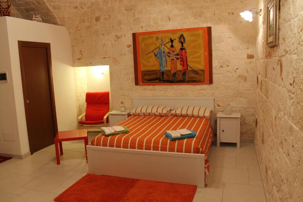 カステッラーナ・グロッテにあるB&B La Pietraのベッドルーム1室(ベッド1台付)が備わります。壁には絵画が飾られています。