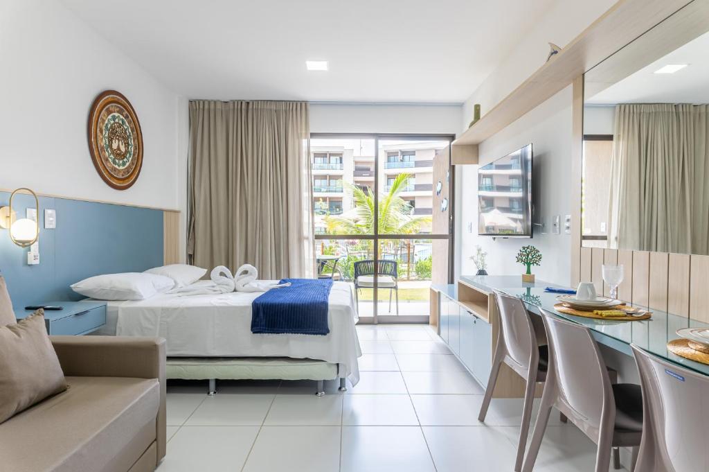 ein Hotelzimmer mit Bett und Küche in der Unterkunft APE aconchegante e lindo - MALIA-FLAT07 - Muro Alto-Porto de Galinhas in Ipojuca