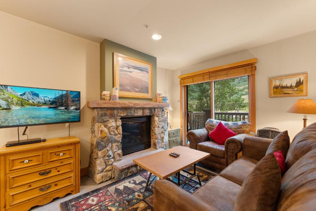a living room with a fireplace and a tv at Expedition Station 8574 by Summit County Mountain Retreats in Snake River Health Services Incorporated Heliport