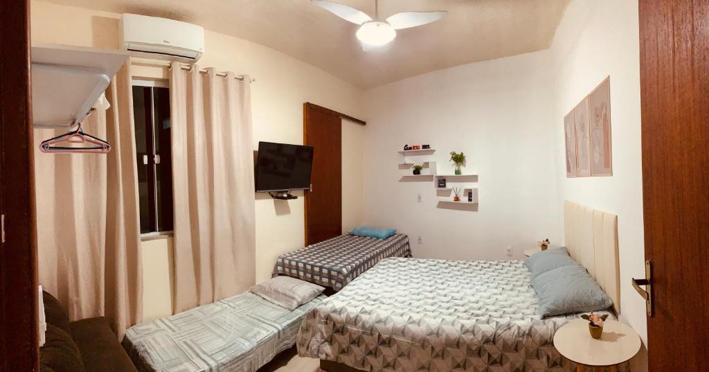 a small room with a bed and a table at Jesaluguel-de-casa in Cabo Frio