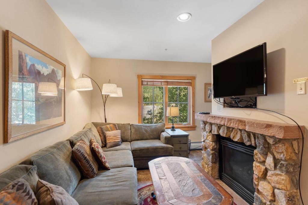 a living room with a couch and a fireplace at Expedition Station 8576 by Summit County Mountain Retreats in Snake River Health Services Incorporated Heliport