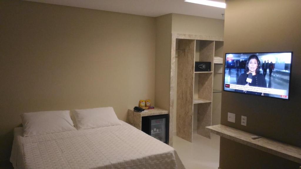 a bedroom with a bed and a flat screen tv at Uchôa Teresina Hotel in Teresina
