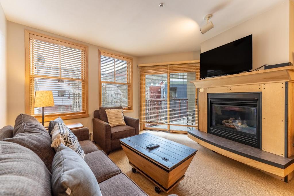 ein Wohnzimmer mit Kamin und Fernseher in der Unterkunft Silver Mill 8203 in Snake River Health Services Incorporated Heliport