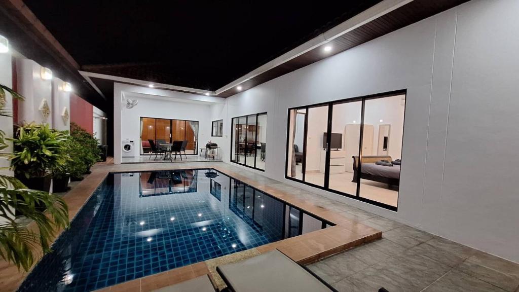 a swimming pool in a house with a living room at Majestic Residence 2Bedroom PoolVilla51, Beach Gate in Pattaya South