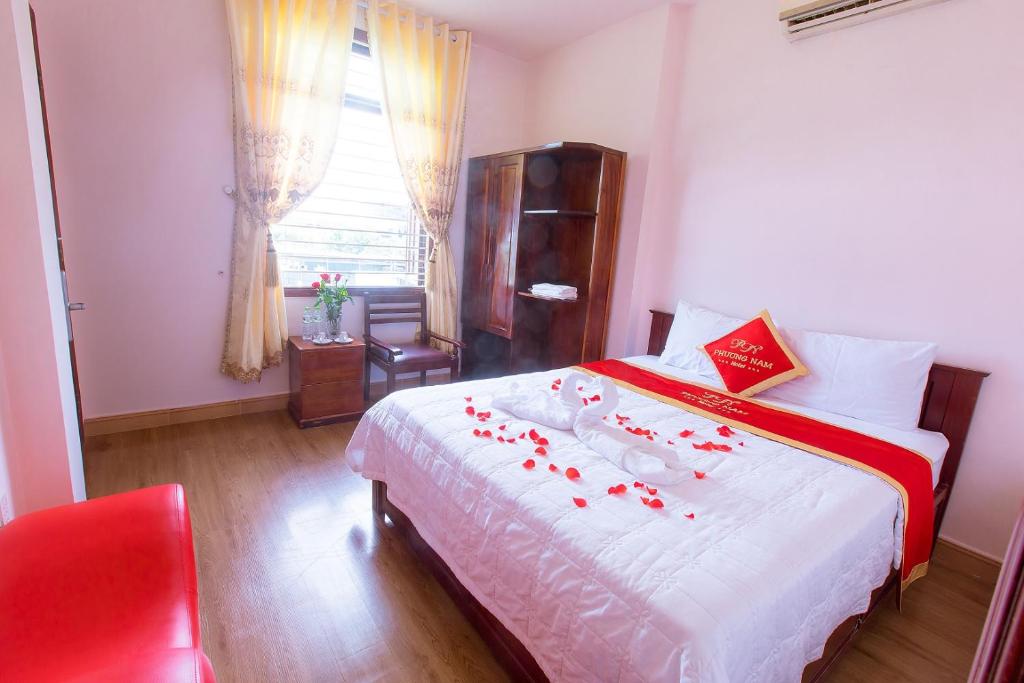 Un dormitorio con una cama con rosas rojas. en Phuong Nam Hotel, en Ho Chi Minh