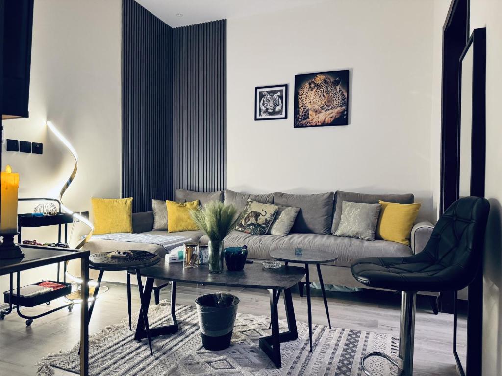 a living room with a couch and tables at Modern Apartment in Jeddah