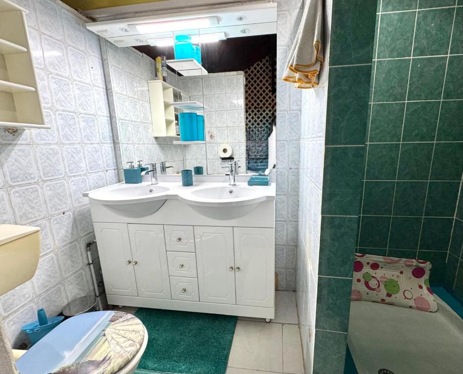 ein Badezimmer mit Waschbecken, Toilette und Spiegel in der Unterkunft Paradis Créole à Bellevue Sainte-Rose in Sainte-Rose