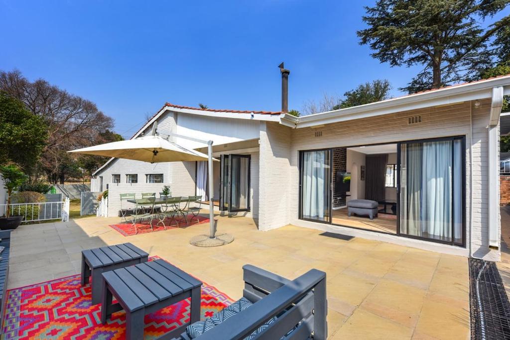 Casa con patio con mesa y sombrilla en Cosy Home close to Sandton, en Johannesburgo