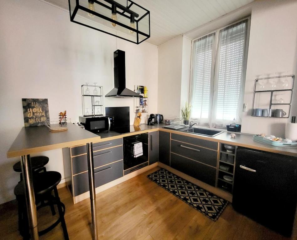 a kitchen with a counter with a sink and a stove at Escale meublée in Belfort
