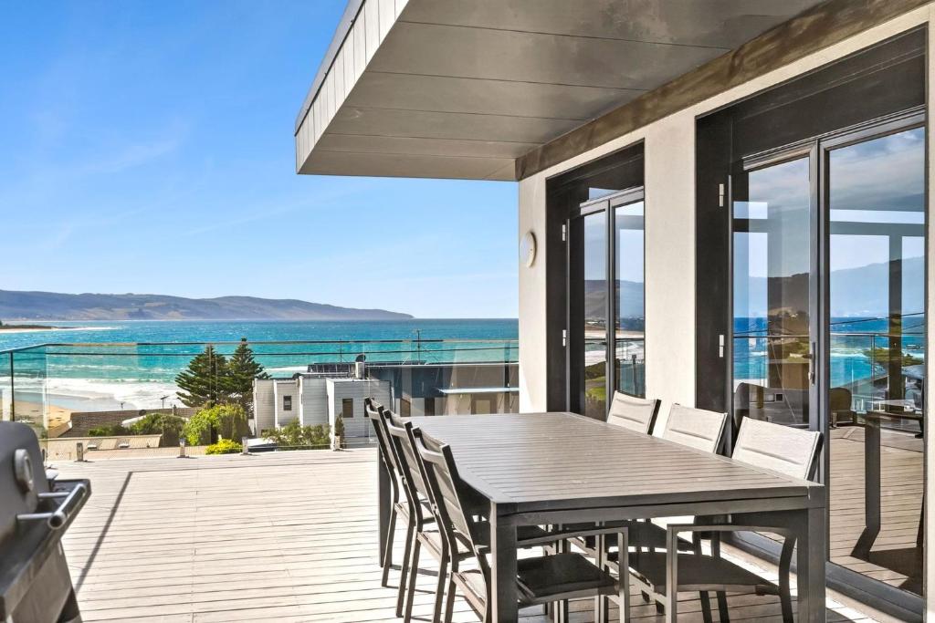 a wooden table and chairs on a deck with the ocean at Casa del Mar in Marengo