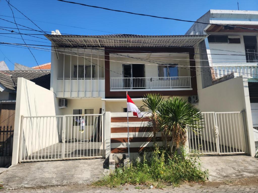 a white house with a flag in front of it at OYO 94780 Blessing Homestay in Pandjangdjiwo