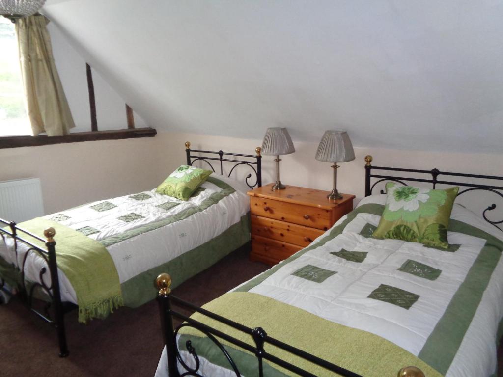 1 Schlafzimmer mit 2 Betten und einer Holzkommode in der Unterkunft Minsmere Cottage in Yoxford