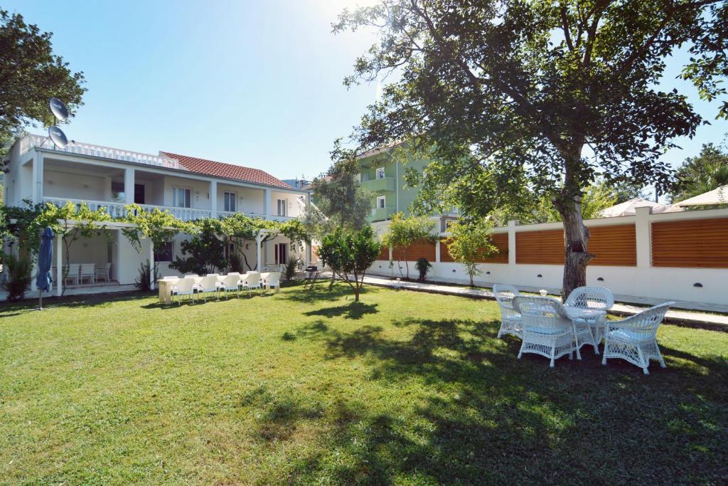 布德瓦的住宿－Jaz Garden Residence，一个带椅子和一棵树的院子和一座建筑