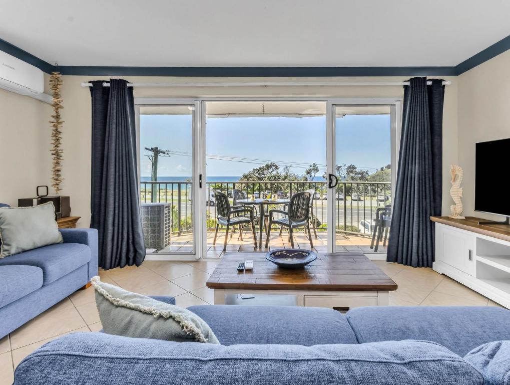 a living room with a couch and a table with a view at Cabarita Beachfront Ocean View 12 in Cabarita Beach