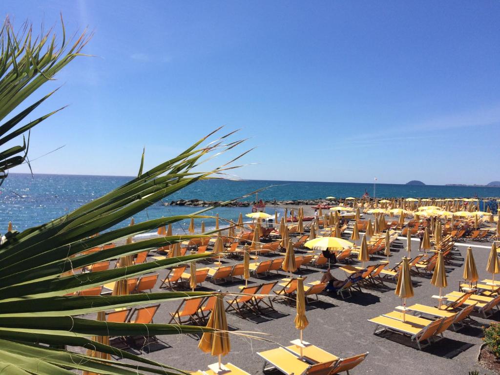 a bunch of chairs and umbrellas on a beach at Casa Smeraldo in Loano