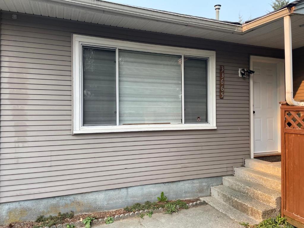 a house with a window with a shutter at Central Vally Private House in Abbotsford