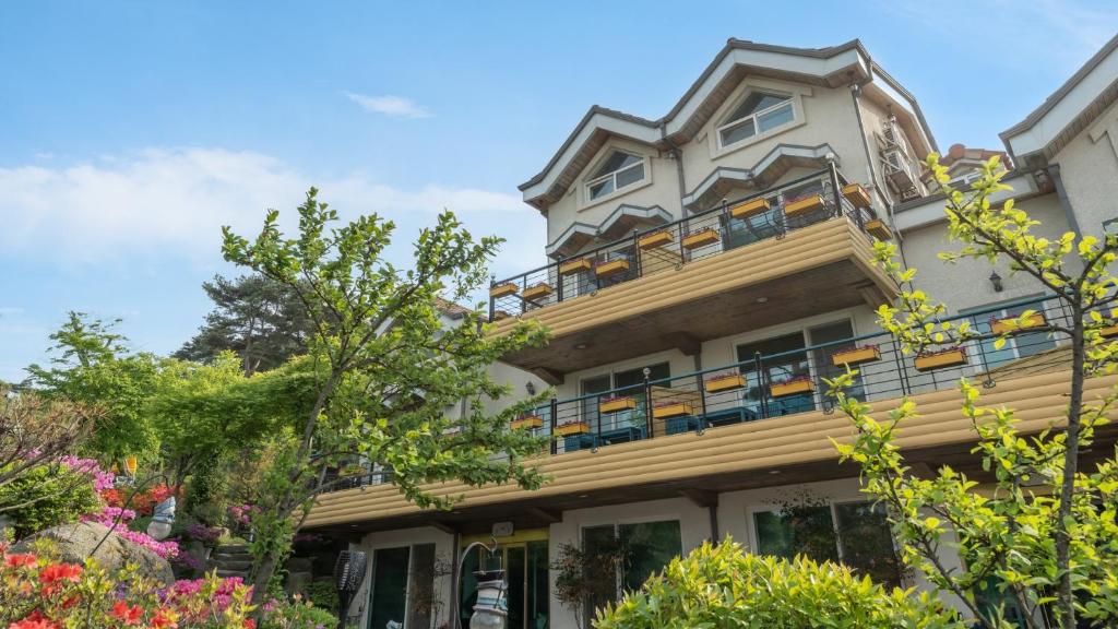 an apartment building with balconies and trees at Gangwha Jeongwon Pension in Incheon
