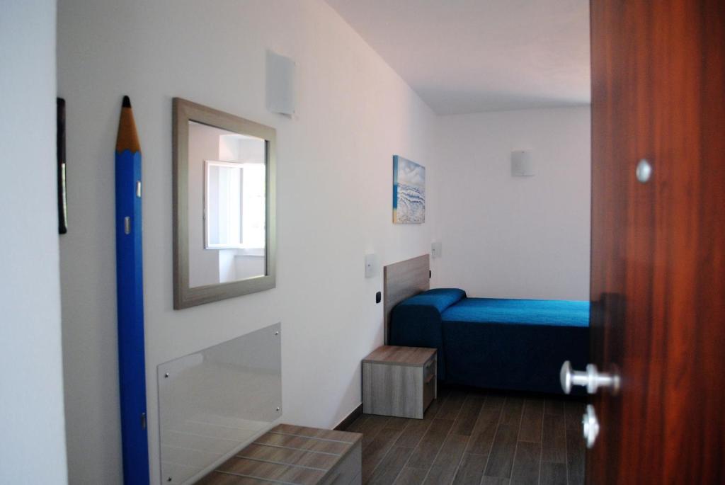 a small bedroom with a blue bed and a mirror at Affittacamere Piazza Castello in Manarola
