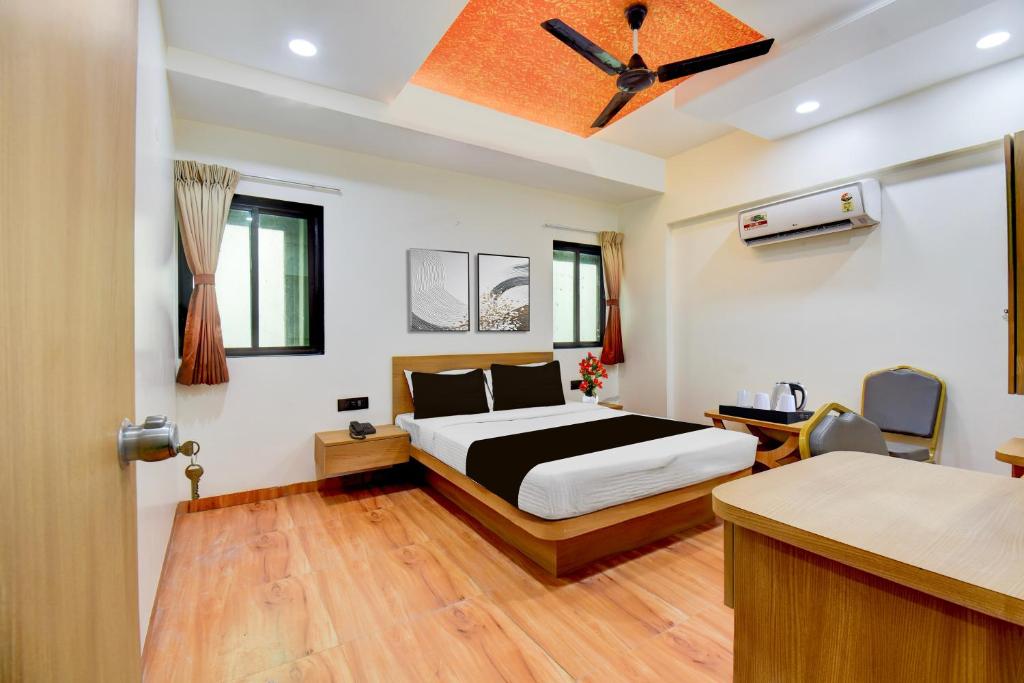 a bedroom with a bed and a ceiling fan at Super Townhouse Balewadi Stadium Pune Formerly Hotel Sarovar in Pune