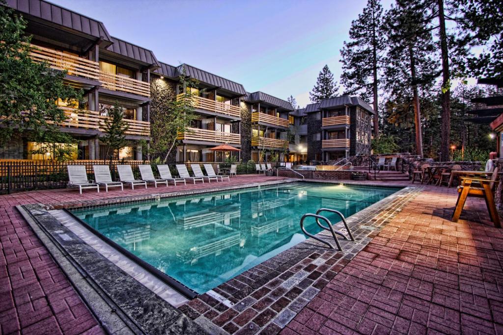 a pool with a pool table and chairs in front of a building at Hotel Azure in South Lake Tahoe
