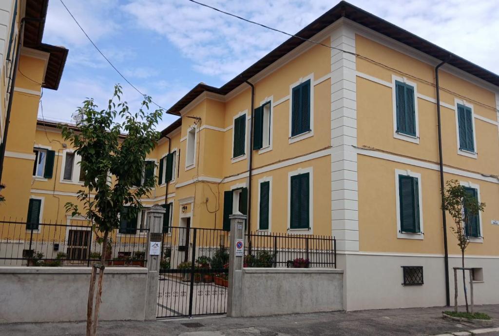 a yellow and white building with a fence at Marruvium 1937 in Avezzano