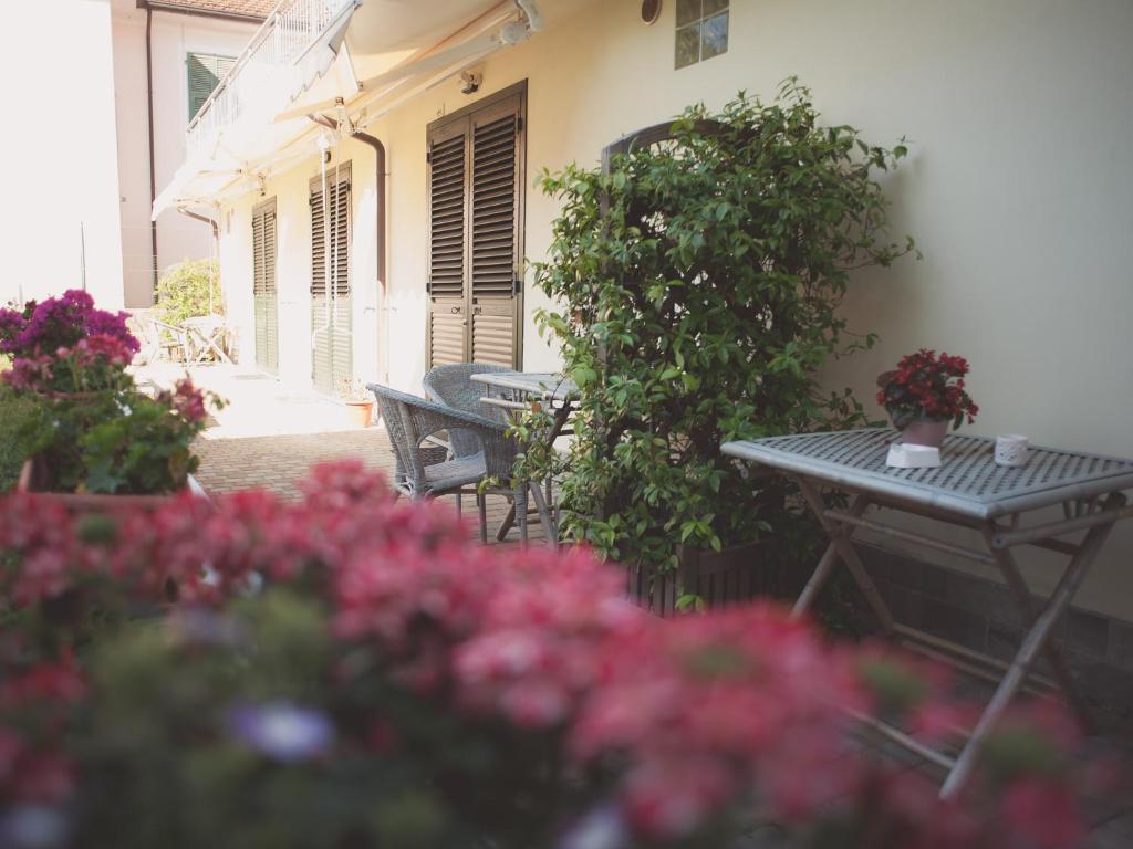 un patio con mesa, sillas y flores en Pian di luna, en Sarzana