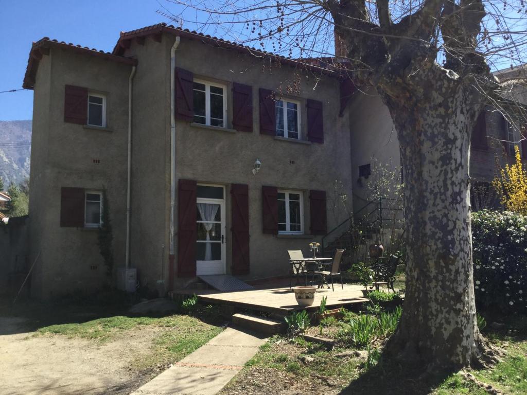 a large house with a table and a tree at Villa Delphina in Vernet-les-Bains