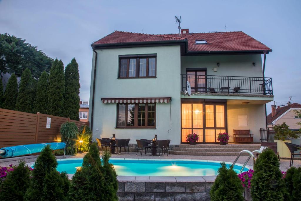 a house with a swimming pool in front of it at Villa Grande - Apartmány in Olomouc
