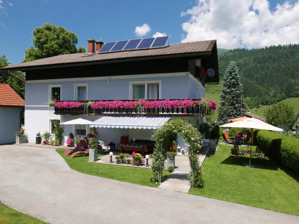 Gästehaus Reicher في أفريتز: منزل به سقف شمسي وبه زهور