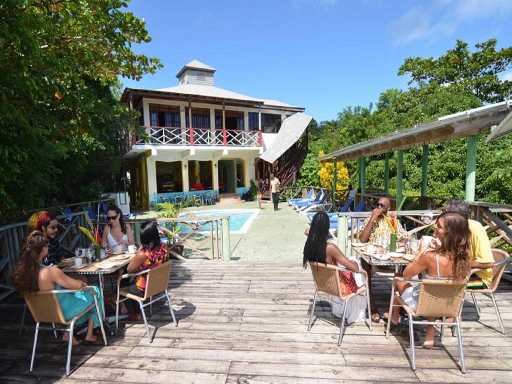 um grupo de pessoas sentadas em mesas em frente a um edifício em Bay View Eco Resort & Spa em Port Antonio