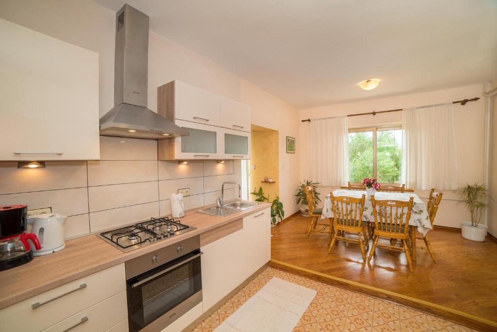 a kitchen and dining room with a table and chairs at Apartment Anica in Rab
