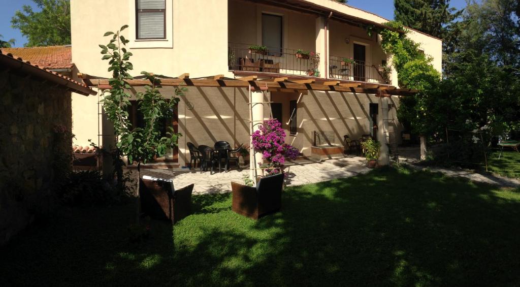 uma casa com uma varanda com uma mesa e cadeiras em Agriturismo Casal Taccone em Tarquinia