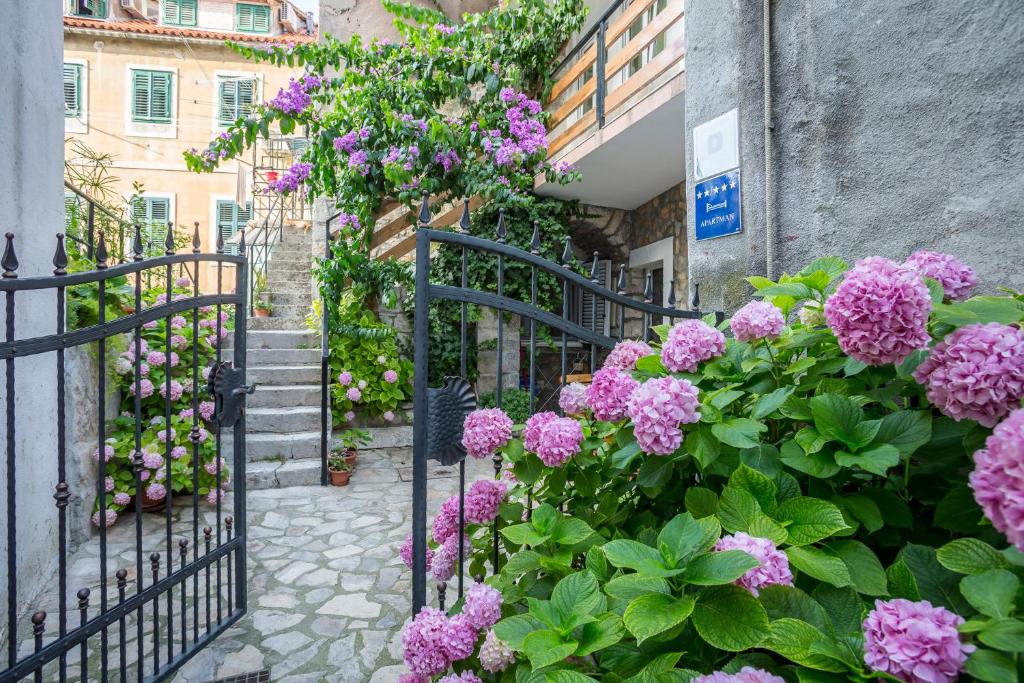 een bos roze bloemen op een gebouw bij Apartments Sara in Split