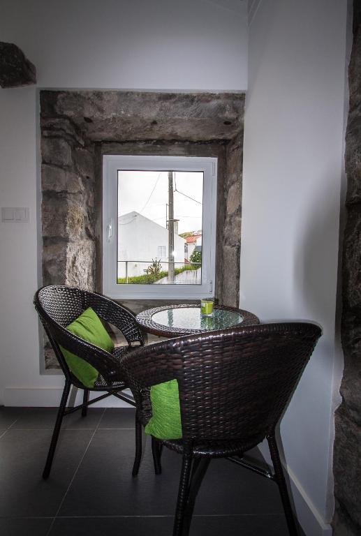 a table and chairs in a room with a window at Casa do Simão in Nordeste