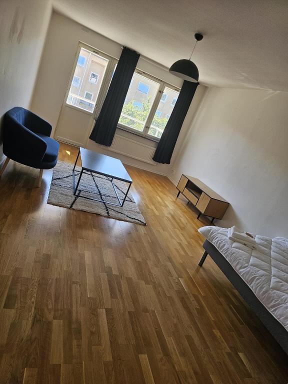 a living room with a bed and a chair in it at Katrineholm Longstay - Fully equipped 2-room apartment in Katrineholm